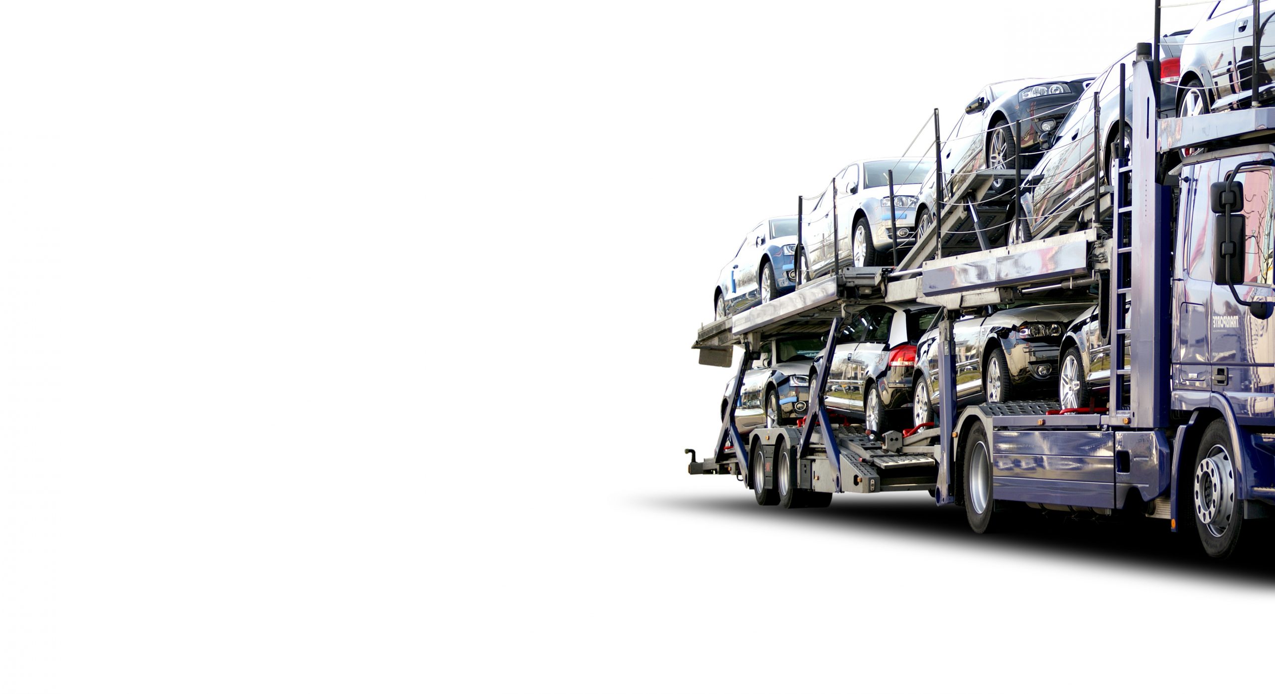 Ein mit mehreren Fahrzeugen beladener Autotransporter auf zwei Ebenen, der auf einem weißen Hintergrund mit viel freiem Raum auf der linken Seite des Bildes fährt.