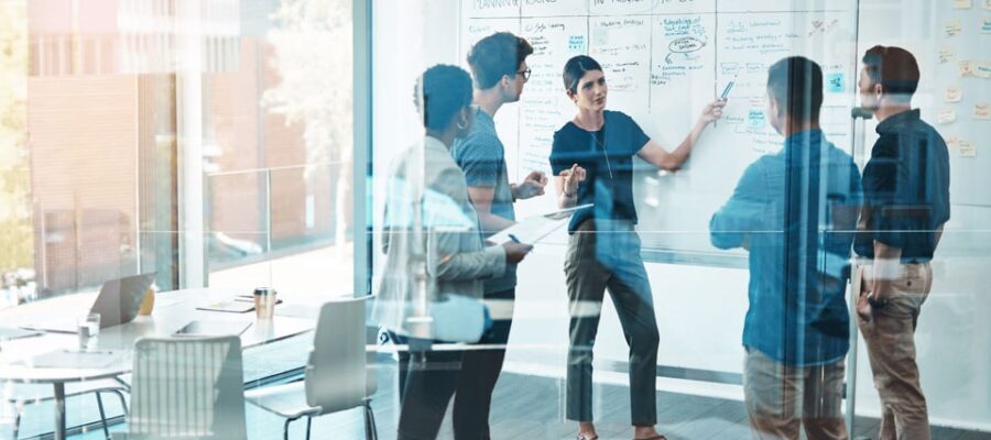 Controlling 4.0 Cover image - Employees discuss modern processes in Controlling 4.0 on a whiteboard - focus on agile planning, task distribution and data-based management