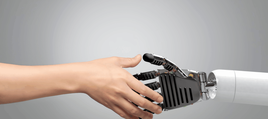 Menschliche Hand berührt vorsichtig eine Roboterhand in moderner Umgebung – symbolisch für Zusammenarbeit zwischen Mensch und künstlicher Intelligenz.
