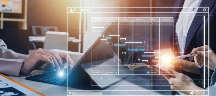 Business-Intelligence-Analyse mit Gantt-Diagramm auf Laptop und Tablet – zwei Personen planen datengetriebene Workflows mit Augmented Analytics im Büro
