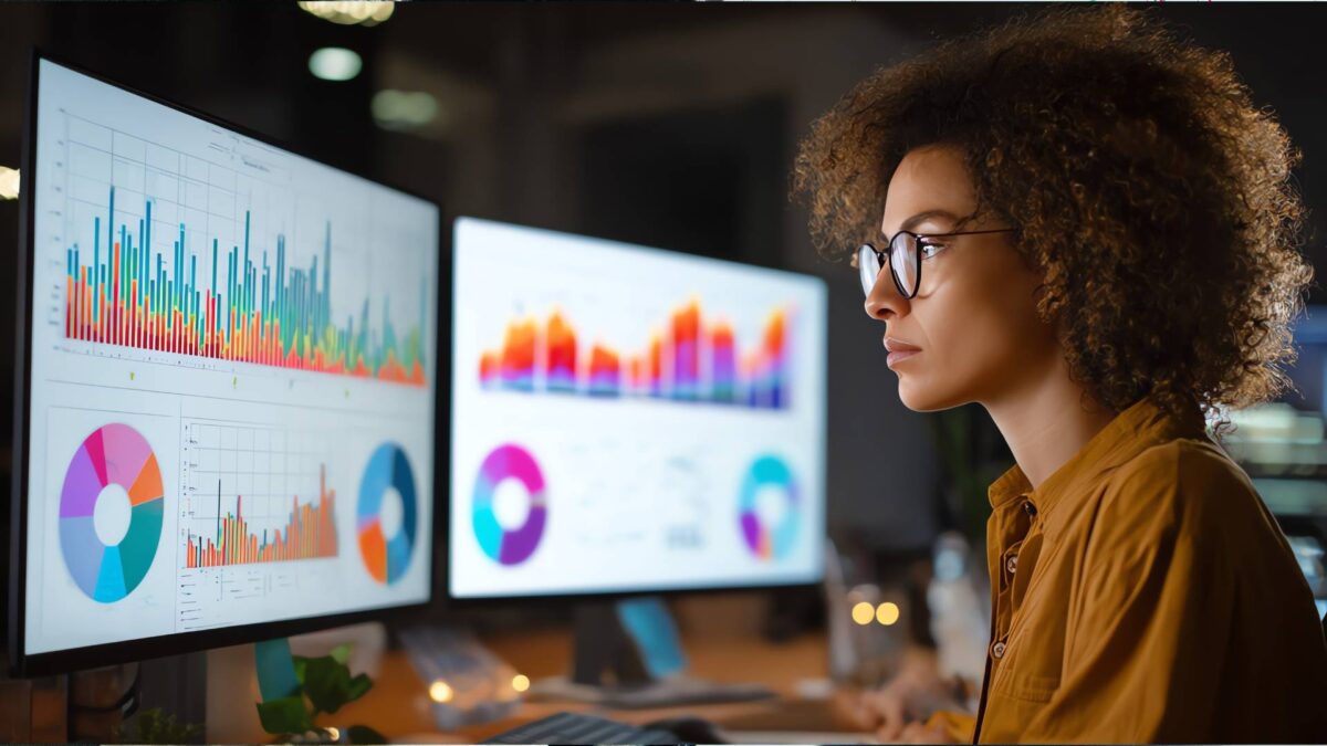 Predictive Analytics Cover image. Data analyst viewing interactive charts and dashboards on two monitors to evaluate predictive analytics results.