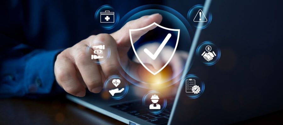 A hand taps on a laptop and brings up digital security symbols and a protective shield with a check mark.
