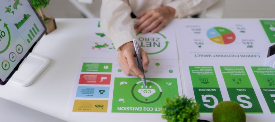 ESG Data Management Cover image. Person analyzes ESG data and CO₂ emissions at a desk with charts and a net-zero monitor for sustainable corporate management.