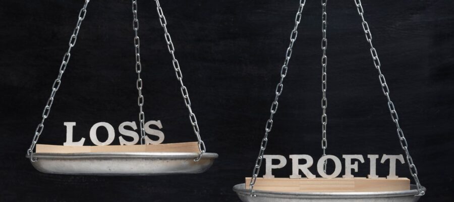 Waage mit den Begriffen „Loss“ und „Profit“ auf gegenüberliegenden Schalen als Symbol für Gewinn- und Verlustrechnung und den Vergleich von Aufwand und Ertrag im Controlling.